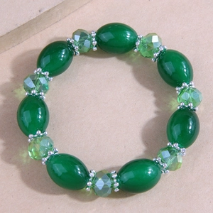 Macro detail of handmade beaded bracelet with green resin beads and silver spacers
