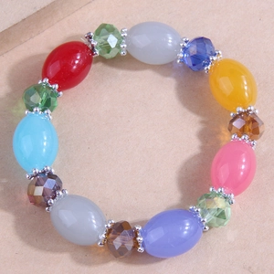 Detailed view of multi-colored beaded bracelet with silver spacers on textured background