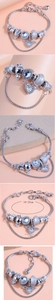 Detail of silver beaded bracelet featuring heart charms and crystal beads with size info