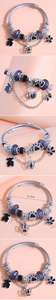 Detail view of silver charm bracelet with bear, crown, and purple bead charms and dimensions