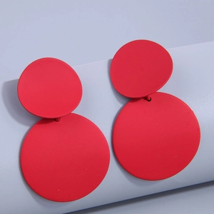 Close-up of geometric red matte round double disc drop earrings with textured finish