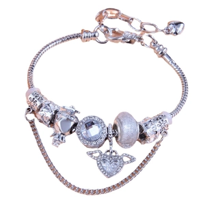 Silver snake chain bracelet with crystal charms and winged heart pendant on white background