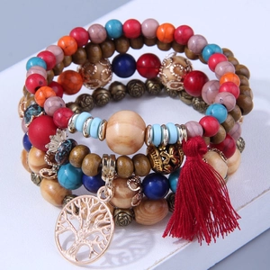 Detailed close-up of bohemian multilayer wood bead bracelet with red tassel and tree pendant