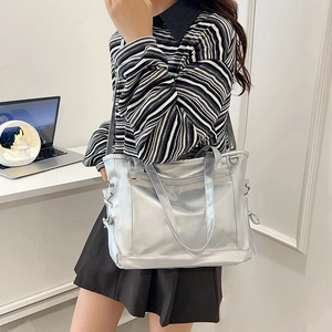 Silver metallic tote bag with large capacity and adjustable strap shown on a model