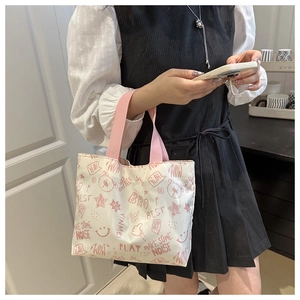 Détail du sac en toile blanche avec imprimés ours roses et poignées tissées