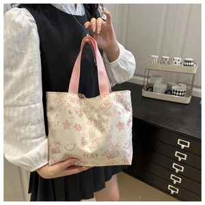 Vue détaillée du sac fourre-tout crème avec imprimés griffonnages roses et anses
