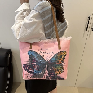 Pink canvas tote bag with butterfly print, fringe edges and brown leather straps