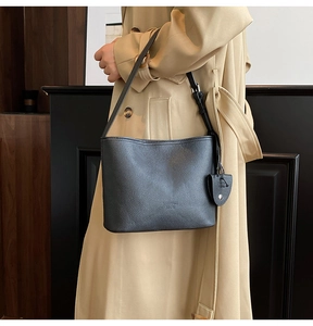 Detail of black lychee grain leather tote bag showing texture and adjustable shoulder strap