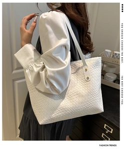 Detail of white woven tote bag showing premium PU leather texture and golden rivets