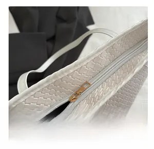 Detailed close-up of smooth gold zipper closure on minimalist woven tote bag
