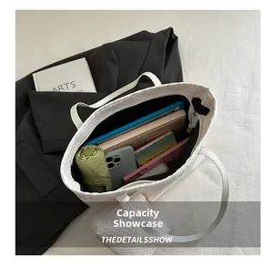 Spacious white woven tote bag showing large interior capacity with a small inner pouch