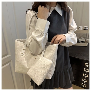 Detailed view of white woven leather tote set featuring main bag and matching small pouch
