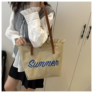 Détail du sac cabas en toile beige avec broderie Summer bleue et bandoulière en cuir
