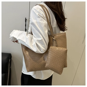 Close-up of woven textured taupe tote bag and matching clutch pouch with slim straps