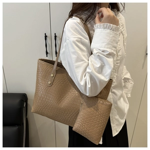 Detail of khaki brown tote bag with crocodile pattern and matching zipper pouch