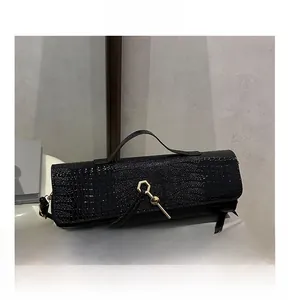 Close-up of black crocodile pattern leather handbag with gold hexagonal lock detail