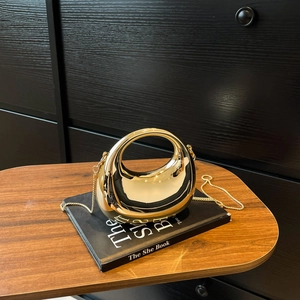 Chic semi-circular gold metal evening bag with glossy mirror finish and chain strap