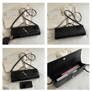 Detail view of black crocodile pattern baguette bag showing size, interior and side profile