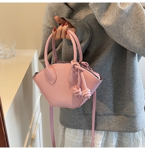 Détail du sac coquille rose géométrique avec nœud décoratif et bandoulière amovible