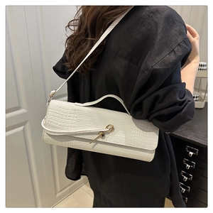 Close-up of white crocodile pattern baguette bag with golden hexagonal metal lock