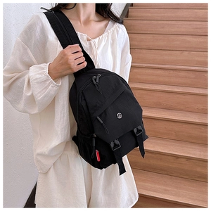 Detail van zwarte nylon crossbodytas met verstelbare riem en een gespsluiting
