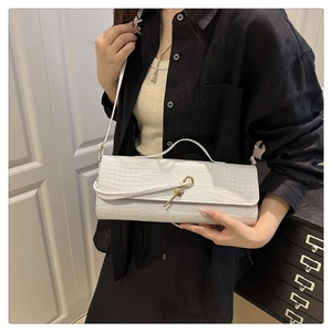 White baguette bag with crocodile texture and unique gold key-shaped metal buckle detail