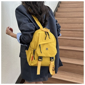 Detail van een felgele waterdichte nylon rugzak met multi-pocket ontwerp en gespen