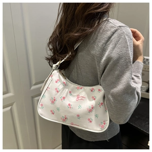 Detail of floral shoulder bag with pink roses, bow pattern and golden metal zipper