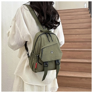 Achteraanzicht van de olijfgroene nylon rugzak met gesp detail en rood mode label