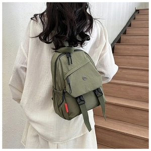 Militaire groene nylon rugzak met gesp en zijvak gedragen door een model