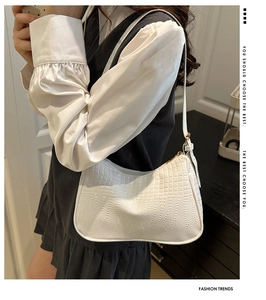 Close-up of white crocodile pattern shoulder bag with sleek PU leather and zipper detail