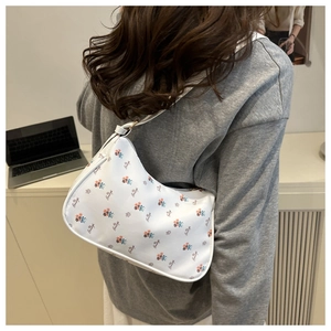 Détail d'un sac sous le bras blanc à motifs floraux vintage avec bandoulière fine