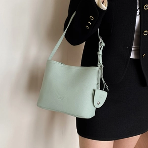 Chic mint green bucket shoulder bag in pebble leather with a mini coin purse charm