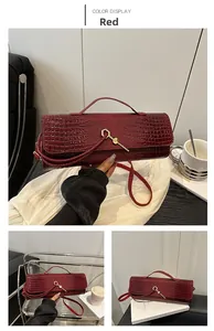 Macro shot of red faux crocodile leather texture and golden lock hardware on the bag