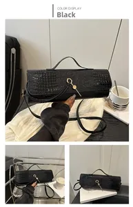 Close-up of black faux crocodile skin texture and golden hexagonal padlock on handbag