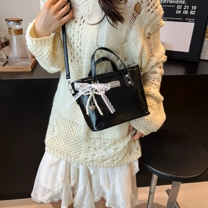 Elegante zwarte glanzende handtas met kanten strik en parelmoer hartje hanger mode