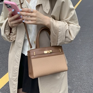 Classic colorblock canvas leather handbag with gold twist lock shown on a female model
