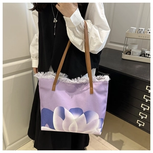 Detalle del bolso de lona morado con estampado floral abstracto y bordes deshilachados
