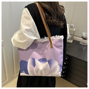 Detalle de bolso tote de lona lila con estampado floral, flecos y correas de cuero