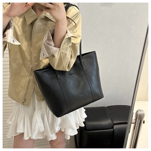 Dettaglio della borsa tote in ecopelle nera con trama fine e spalline sottili ed eleganti