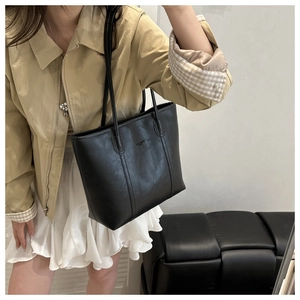 Borsa tote nera in ecopelle martellata abbinata a un outfit da lavoro minimalista
