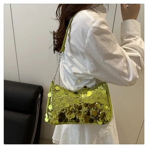 Detail of lime green sequin shoulder bag with silver chain strap and disco style finish