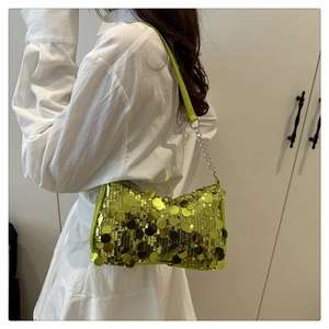 Close-up of lime green sequin underarm bag with reflective metallic circles and chain strap