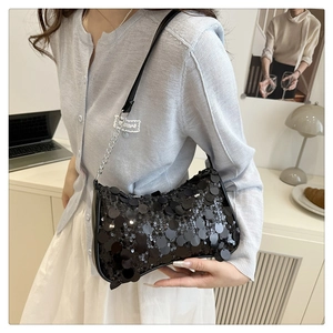 Gros plan du sac sous le bras à paillettes noires avec chaîne argentée sur un modèle