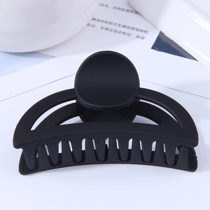 Détail d'une pince à cheveux noire mate arquée avec dents antidérapantes pour cheveux