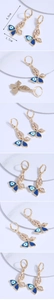Detailed views showing butterfly evil eye earrings with zircon and blue enamel finish