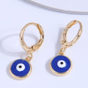Boucles d'oreilles créoles dorées œil protecteur avec émail bleu sur fond blanc pur