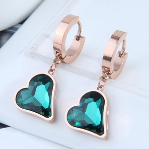 Dettaglio di orecchini a cuore con pietra verde smeraldo e cerchi in oro rosa