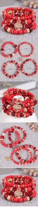 Detail of red beaded multilayer bracelets featuring a hollow tree of life heart pendant