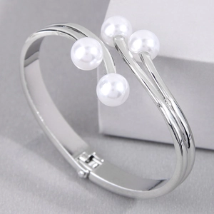 Elegant silver open bangle featuring four lustrous white pearls on a polished finish